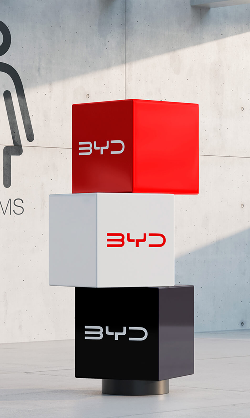 Tótem de cubos con el logotipo de BYD en colores rojo, blanco y negro sobre fondo de pared de concreto